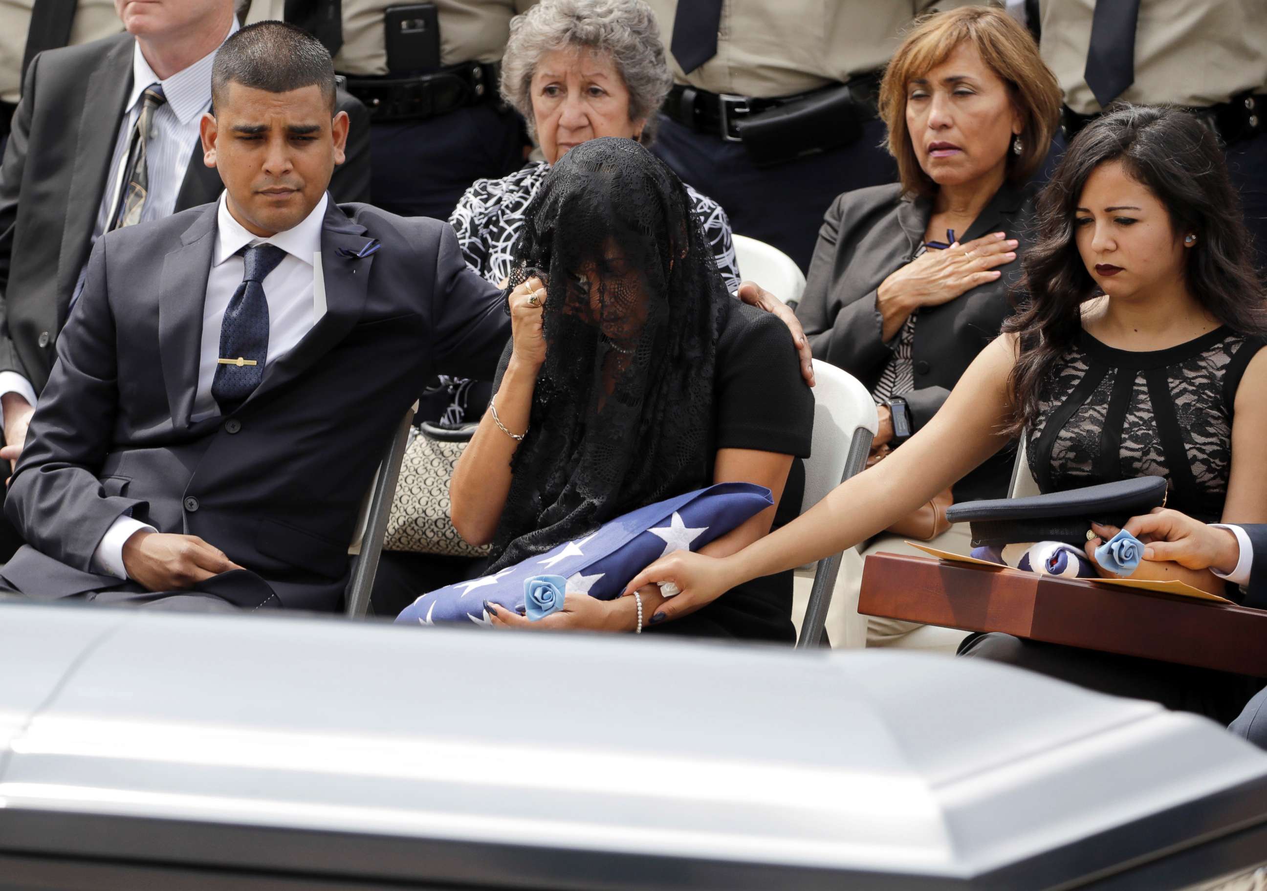 PHOTO: Cheryl Perez, center, is comforted by her son, Maverick, left, and daughter, Sabrina, during a funeral service for her husband, Houston Police Sgt. Steve Perez, Sept. 13, 2017, in Houston. 