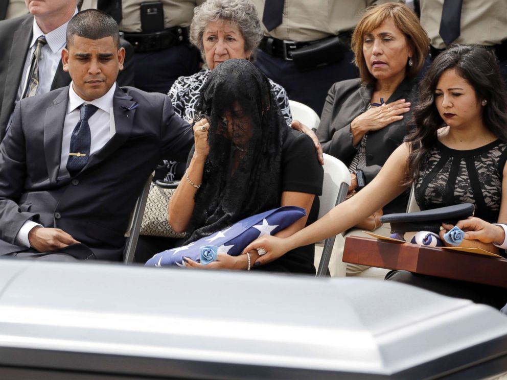 PHOTO: Cheryl Perez, center, is comforted by her son, Maverick, left, and daughter, Sabrina, during a funeral service for her husband, Houston Police Sgt. Steve Perez, Sept. 13, 2017, in Houston.