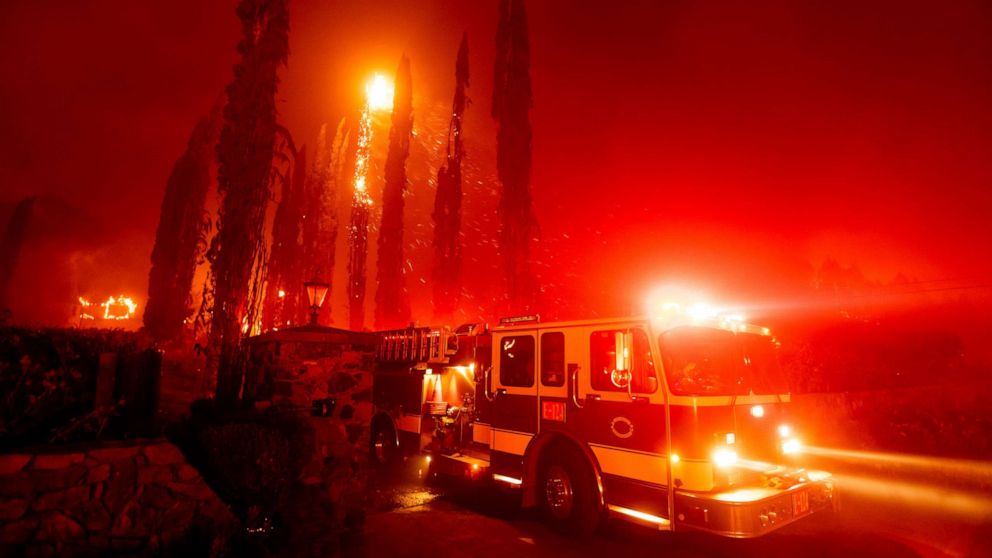 PHOTO: A fire engine leaves a burning property as the Glass Fire tears through St. Helena, Calif., Sept. 27, 2020.