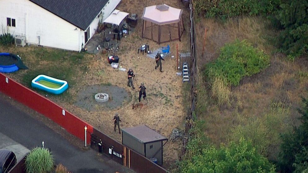 PHOTO: Law enforcement search the backyard of a home in pursuit of three suspects in the fatal shooting of a Clark County, Wash. Deputy Sheriff in Vancouver, B.C., Canada,  July 23, 2021 .