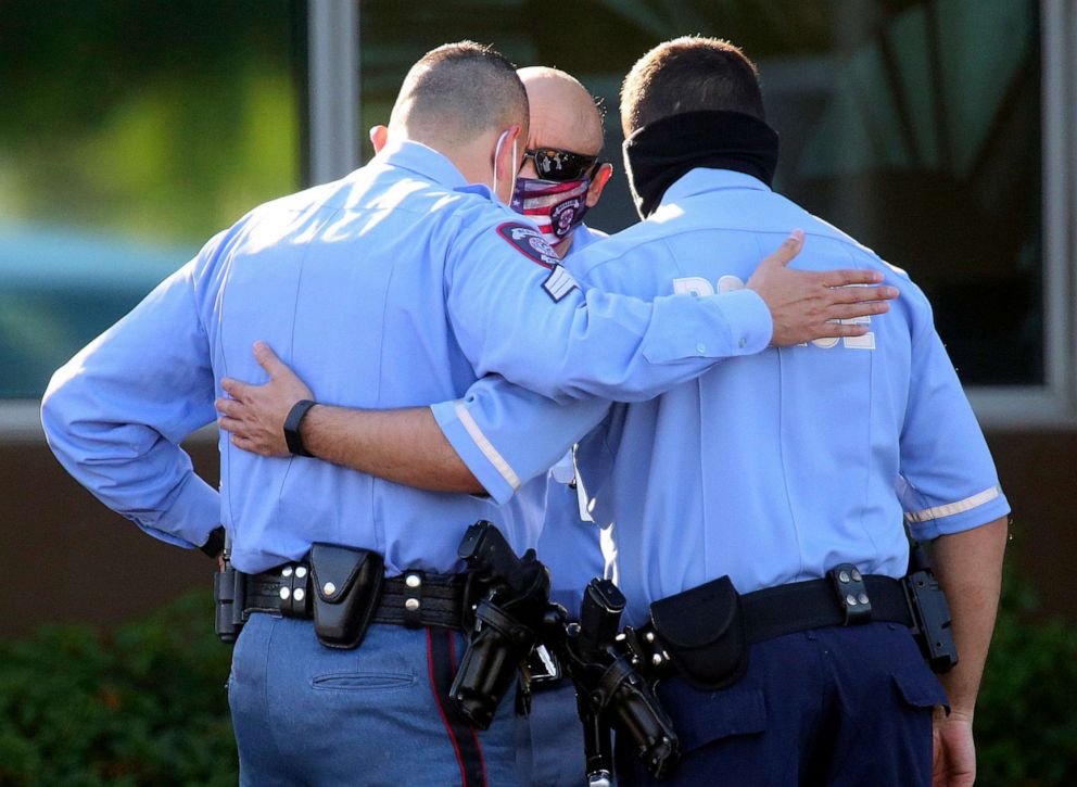 PHOTO: McAllen Police officers console one another as they gather outside the McAllen Medical Center, July 11, 2020, in McAllen, Texas.