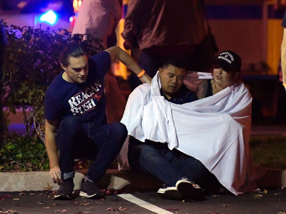 PHOTO: People comfort each other as they sit near the scene, Nov. 8, 2018, in Thousand Oaks, Calif. where a gunman opened fire Wednesday inside a country dance bar crowded with hundreds of people on "college night."