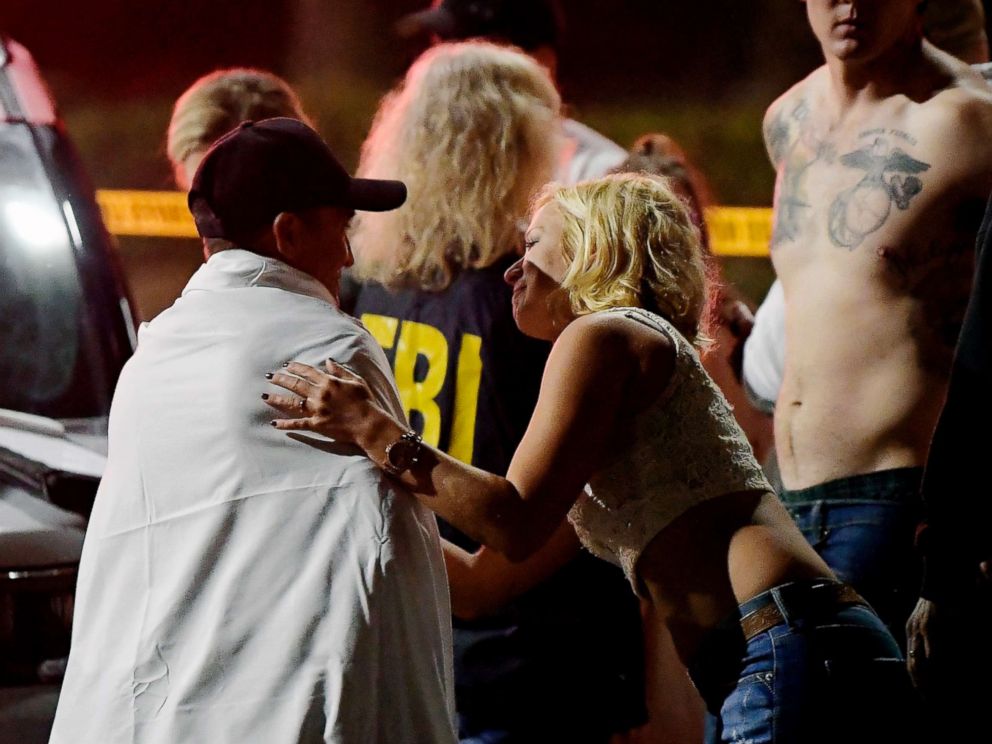 PHOTO: People comfort each other as they sit near the scene, Nov. 8, 2018, in Thousand Oaks, Calif. where a gunman opened fire Wednesday inside a country dance bar crowded with hundreds of people on college night.