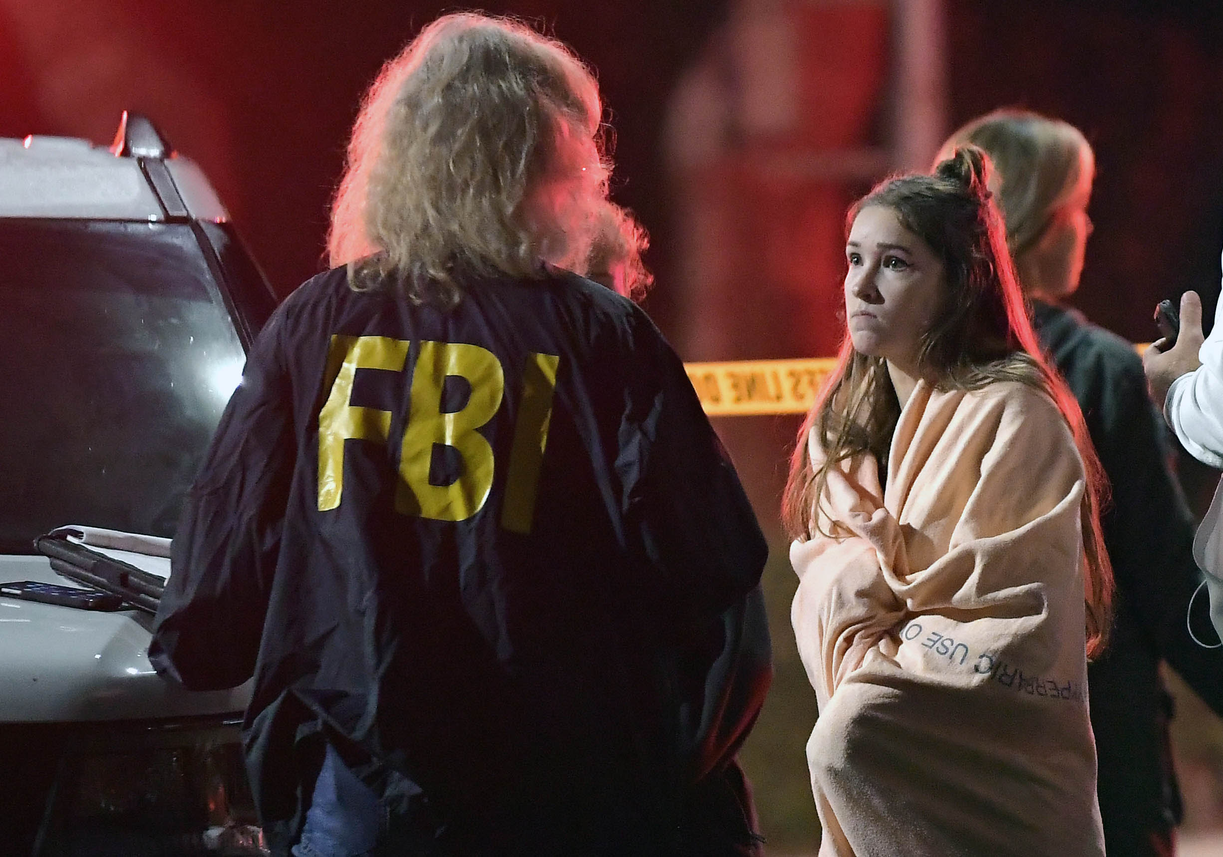 PHOTO: An FBI agent talks to a potential witness as they stand near the scene, Nov. 8, 2018, in Thousand Oaks, Calif. where a gunman opened fire Wednesday inside a country dance bar crowded with hundreds of people on "college night."