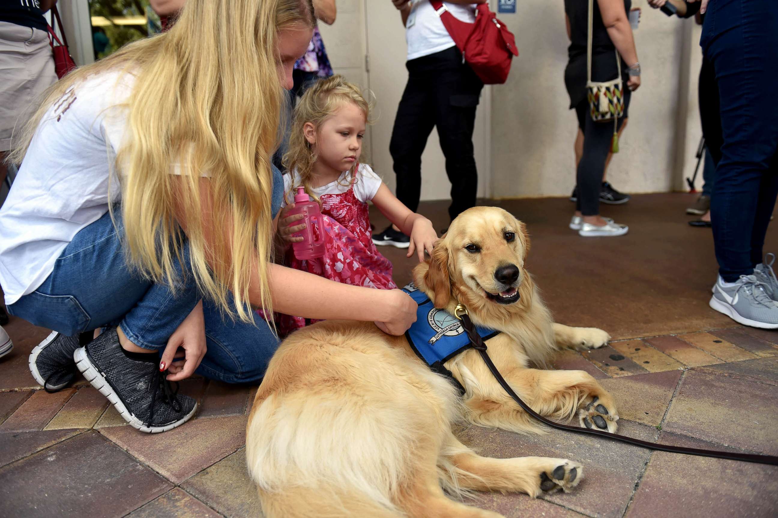 PHOTO: From left, Emmy Halulko, 13, and her sister Evie, 5, pet Jacob, a Lutheran Church Charities comfort dog while at the Parkridge Church in Coral Springs, Fla, Feb. 15, 2018, for a community prayer vigil for the Parkland high school shooting victims.