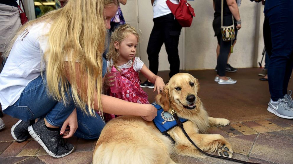 From left, Emmy Halulko, 13, and her sister Evie, 5, pet Jacob, a Lutheran Church Charities comfort dog while at the Parkridge Church in Coral Springs, Fla, Feb. 15, 2018, for a community prayer vigil for the Parkland high school shooting victims.
