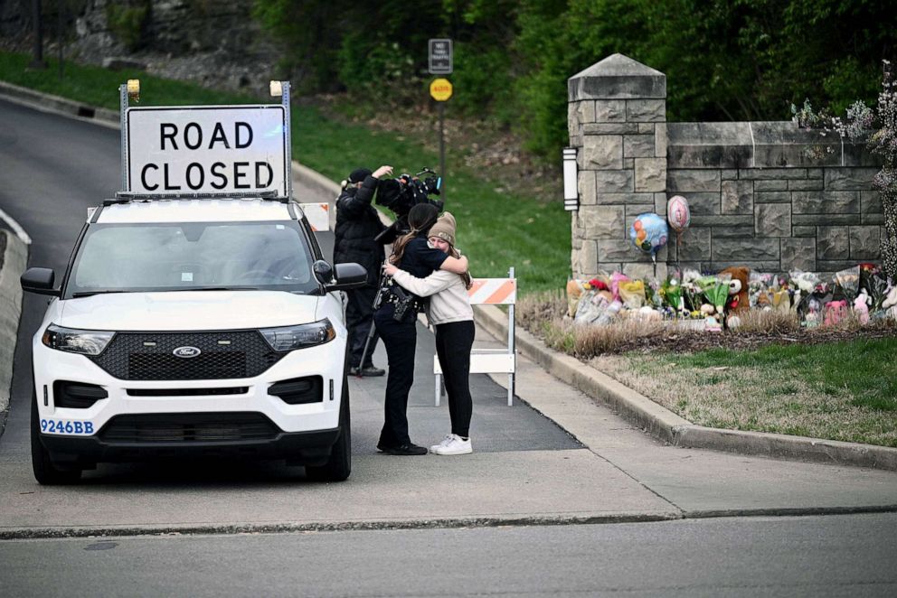 PHOTO: A woman hugs a police officer at the entrance of the Covenant School at the Covenant Presbyterian Church, in Nashville, March 28, 2023.