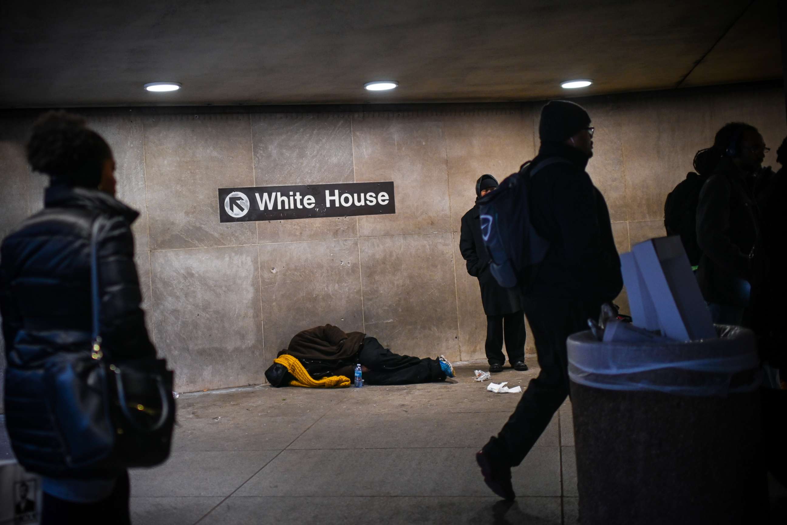 PHOTO: A homeless person sleeps below a sign indicating the exit to the White House at McPherson Square Metro station in Washington, Dec. 12, 2018.