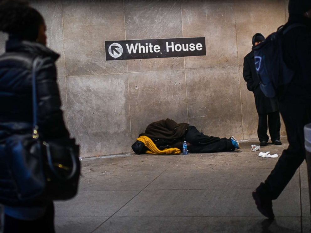 PHOTO: A homeless person sleeps below a sign indicating the exit to the White House at McPherson Square Metro station in Washington, Dec. 12, 2018.