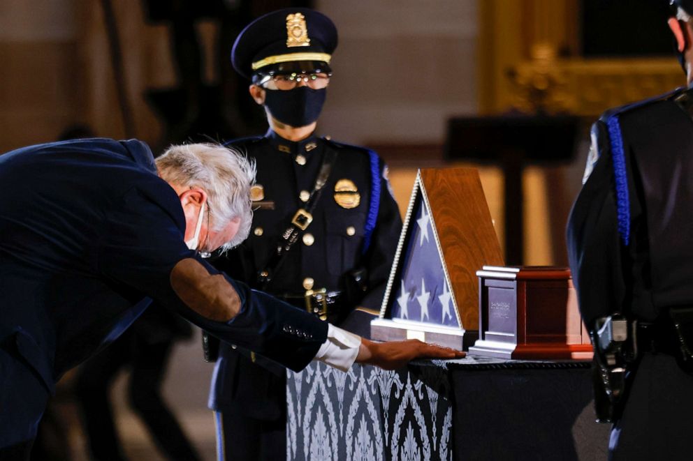 PHOTO: A member of Congress pays his respects to the late U.S. Capitol Police officer Brian Sicknick as an urn with his remains lies in honor on a black-draped table at the center of the Capitol Rotunda, Feb. 3, 2021, in Washington.