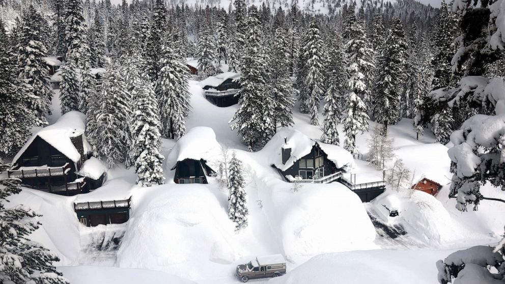 PHOTO: A vehicle navigates a snowy roadway lined with snowbanks piled up from new and past storms in the Sierra Nevada mountains, in the wake of an atmospheric river event, March 12, 2023, in Mammoth Lakes, California.