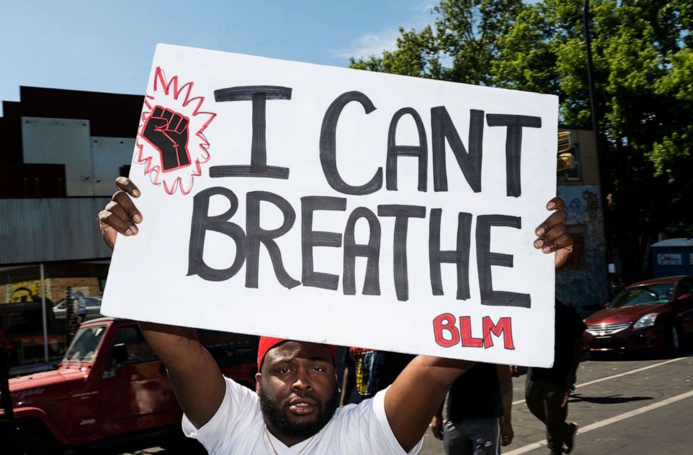 PHOTO: A man holds up a sign stating "I Can't Breathe" at a memorial for George Floyd on June 3, 2020 in Minneapolis.