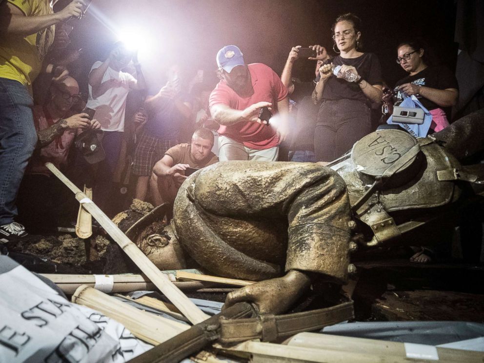 PHOTO: Demonstrators and spectators gather around a toppled Confederate statue known as Silent Sam, Aug. 20, 2018 at UNC-Chapel Hill, N.C