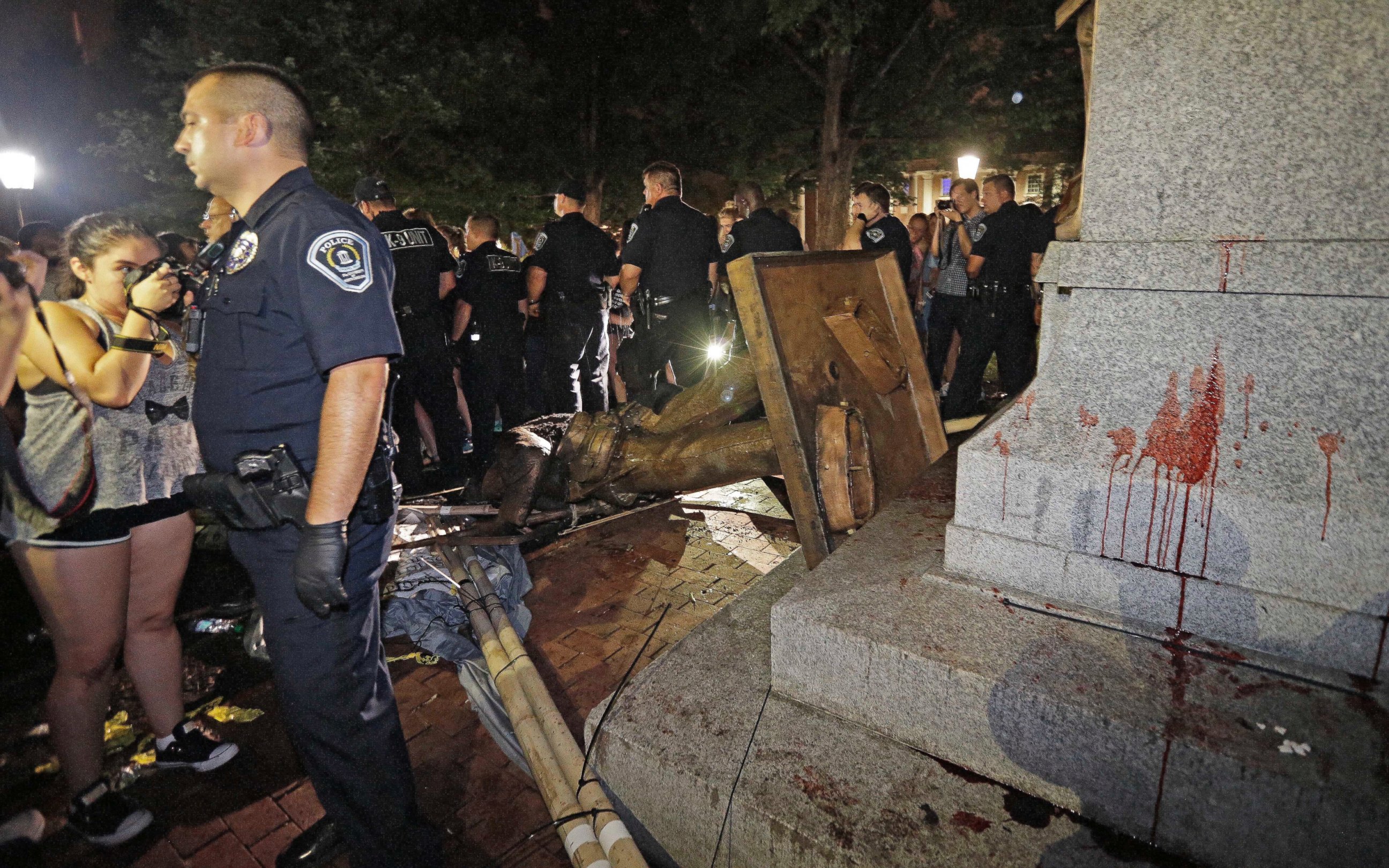 Police stand guard after the confederate statue known as Silent Sam was toppled by protesters on campus at the University of North Carolina in Chapel Hill, N.C., Monday, Aug. 20, 2018. 