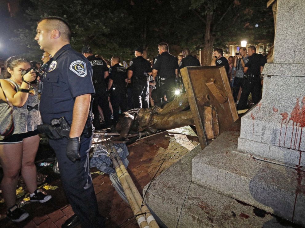 Police stand guard after the confederate statue known as Silent Sam was toppled by protesters on campus at the University of North Carolina in Chapel Hill, N.C., Monday, Aug. 20, 2018.