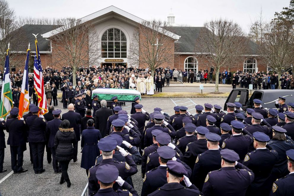 PHOTO: Police officers salute as the remains of fallen NYPD Detective Brian Simonsen are carried toward a Hearse following his funeral service at the Church of St. Rosalie, Feb. 20, 2019, in Hampton Bays, N.Y.