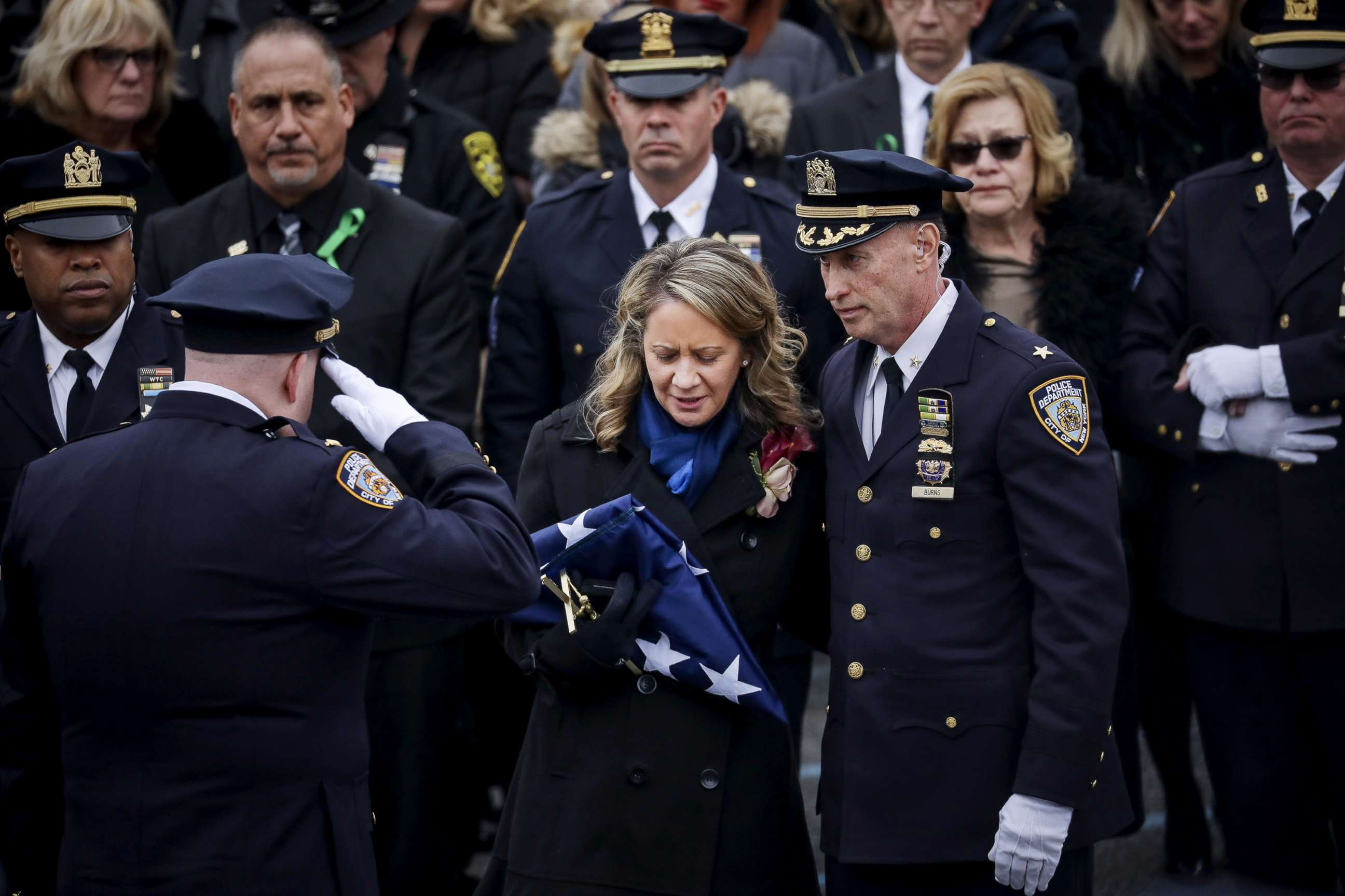PHOTO: Leanne Simonsen, wife of fallen NYPD Detective Brian Simonsen receives a flag after her late husband's remains were carried out of the church following his funeral service at the Church of St. Rosalie, Feb. 20, 2019 in Hampton Bays, N.Y.