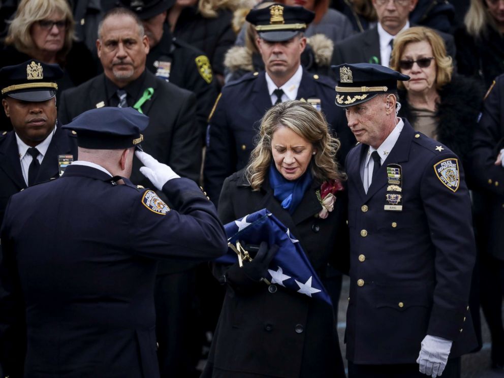 PHOTO: Leanne Simonsen, wife of fallen NYPD Detective Brian Simonsen receives a flag after her late husbands remains were carried out of the church following his funeral service at the Church of St. Rosalie, Feb. 20, 2019 in Hampton Bays, N.Y.