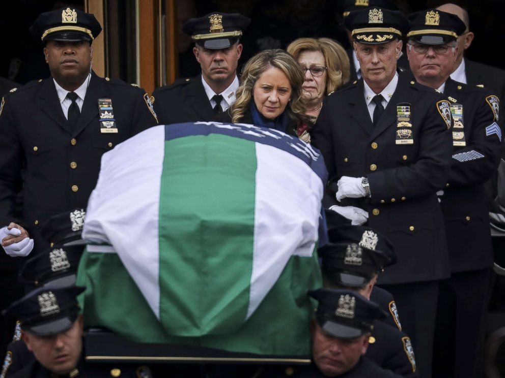 PHOTO: Leanne Simonsen, wife of fallen NYPD Detective Brian Simonsen, is escorted by officers as her late husbands remains are carried out of the church following his funeral service at the Church of St. Rosalie, Feb. 20, 2019 in Hampton Bays, N.Y.