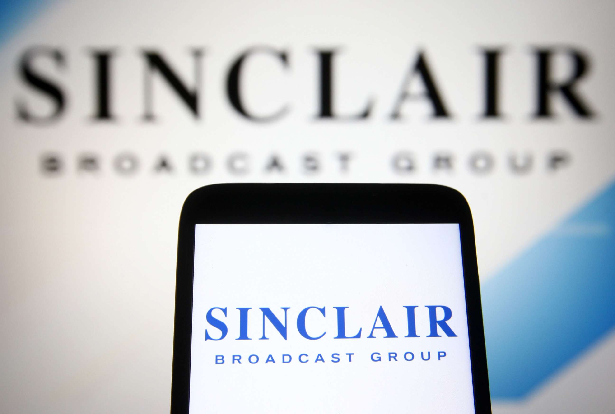 PHOTO: This Aug. 9, 2021, file photo illustration, shows the Sinclair Broadcast Group (SBG) logo is seen on a smartphone and a computer screen.