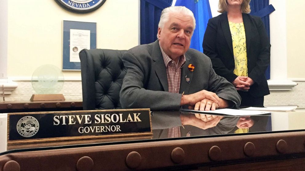 PHOTO: Nevada Gov. Steve Sisolak sits at his desk at the Capitol in Carson City before signing a bill that opens the books on applications for licenses to sell recreational marijuana on May 10, 2019. 
