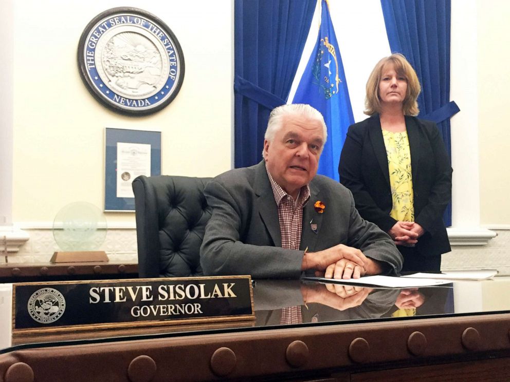 PHOTO: Nevada Gov. Steve Sisolak sits at his desk at the Capitol in Carson City before signing a bill that opens the books on applications for licenses to sell recreational marijuana on May 10, 2019. 