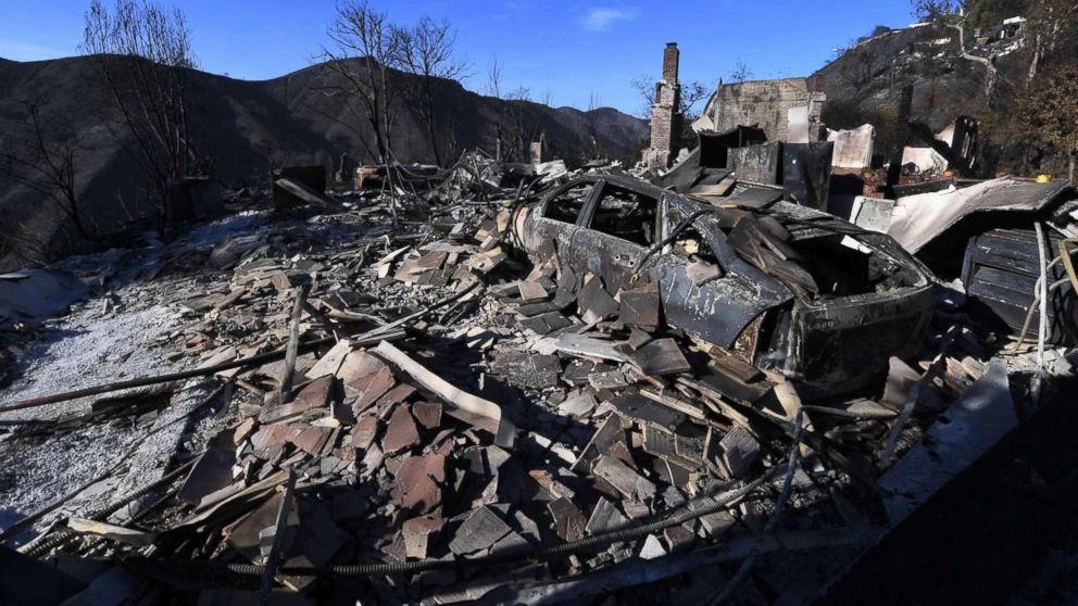 PHOTO: A burnt out house and car are seen after the Skirball wildfire swept through the exclusive enclave of Bel Air, Calif., Dec. 7, 2017.