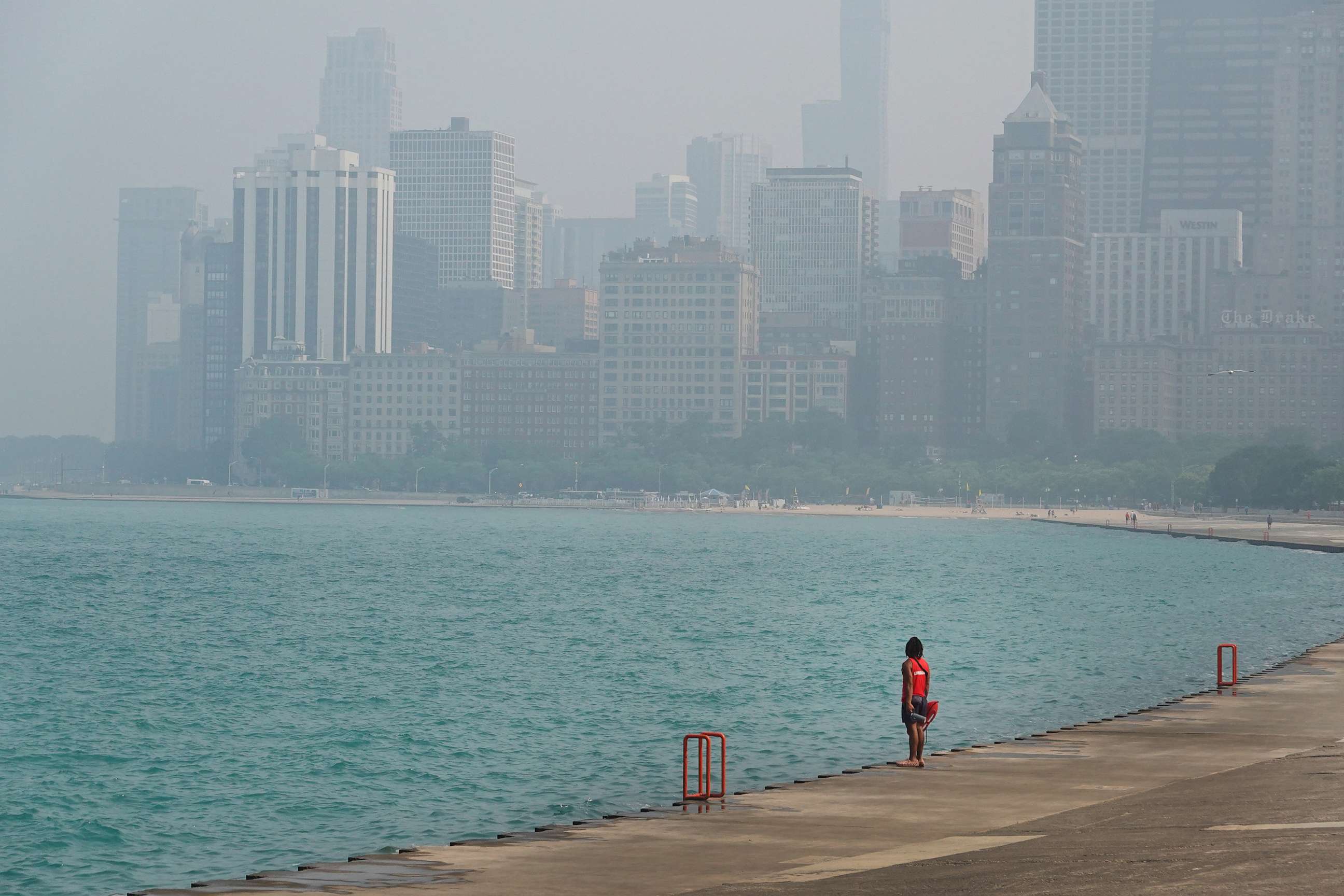 PHOTO: A lifeguard stands watch along the lakefront as wildfire smoke clouds the skyline on June 28, 2023 in Chicago.