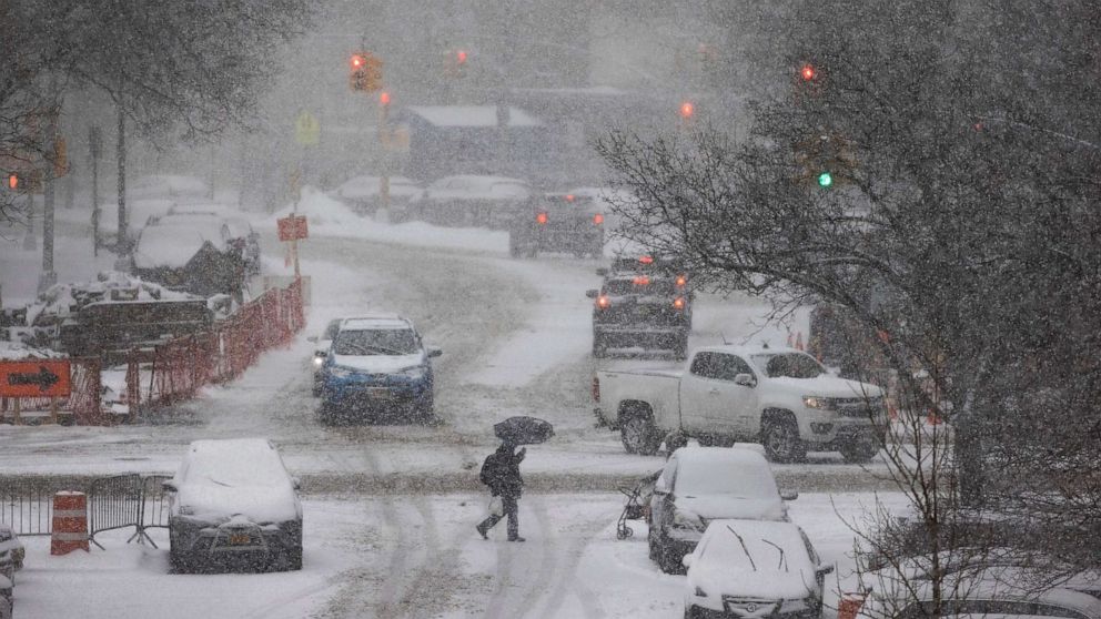 PHOTO: A person crosses a street as snow falls in New York, Feb. 18, 2021. 