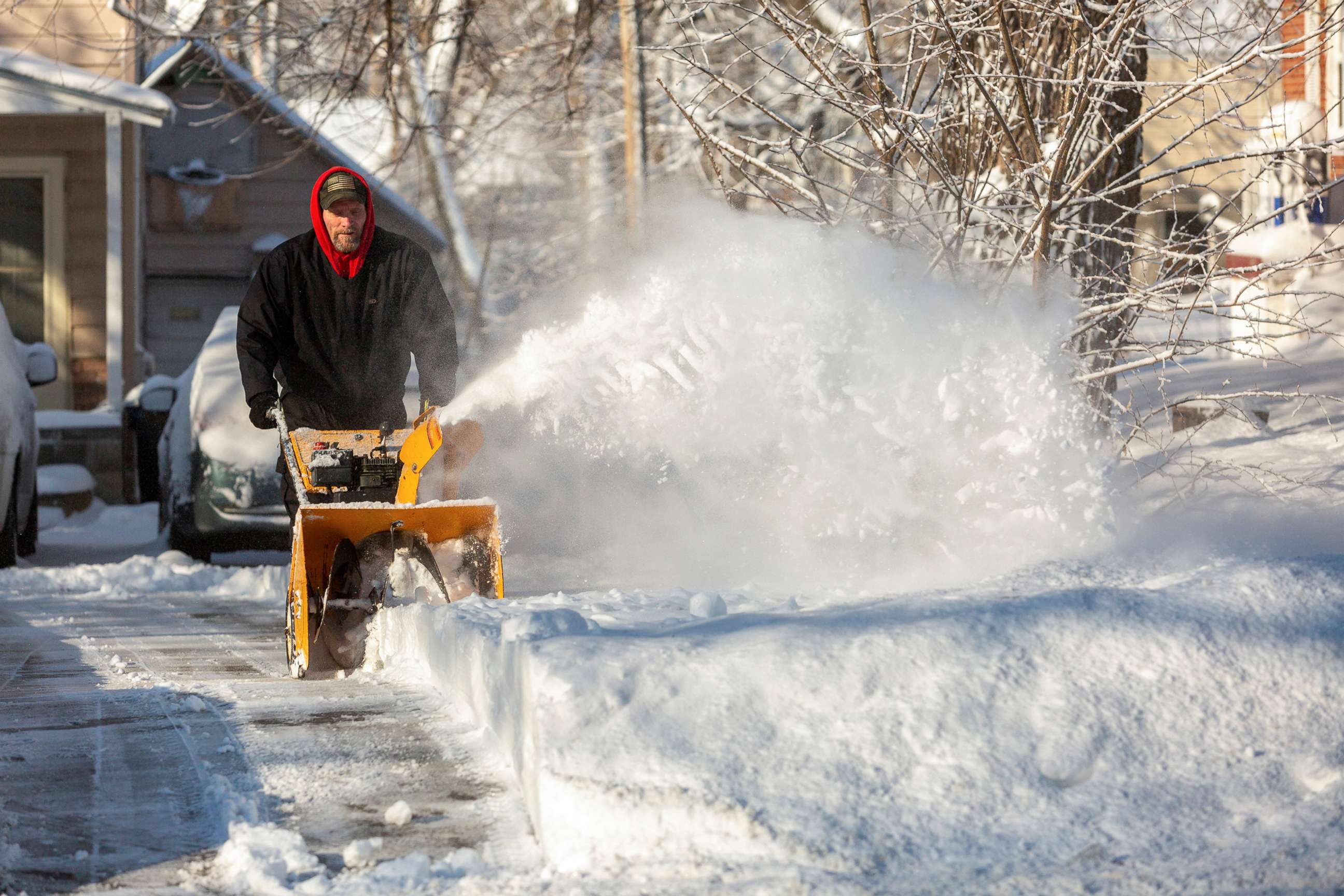 PHOTO: A man snow blows his driveway after Winter Storm Izzy in Des Moines, Iowa, Jan. 15, 2022. 