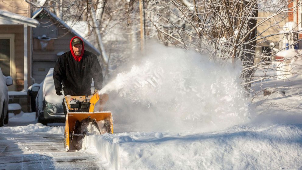 PHOTO: A man snow blows his driveway after Winter Storm Izzy in Des Moines, Iowa, Jan. 15, 2022. 