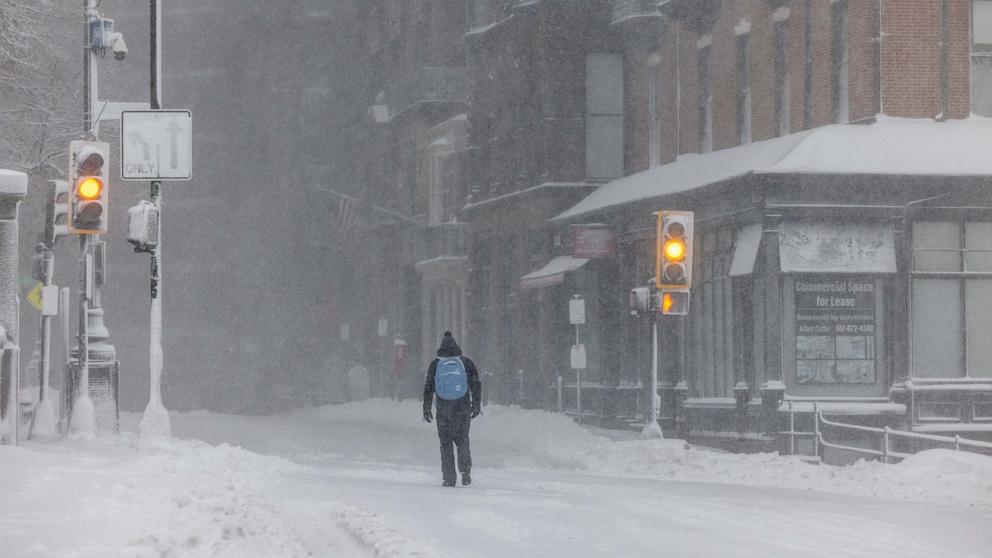 PHOTO: A person walks down Beacon Street during heavy snow, February 23, 2026 in Boston.