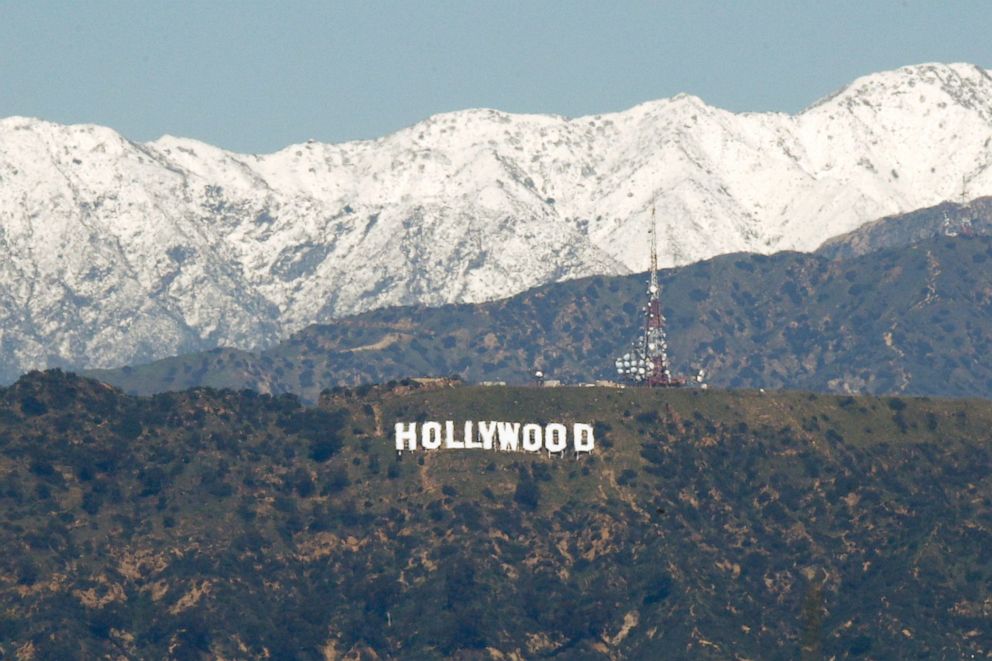 PHOTO: The snow-covered San Gabriel Mountains appear behind the Hollywood sign in Los Angeles, on March 2, 2023.