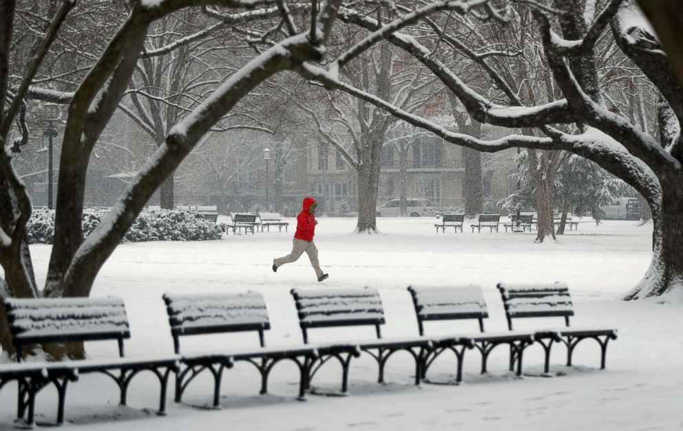 PHOTO: A man runs through Lafayette Park in front of the White House during a snowstorm in Washington, D.C., Feb. 20, 2019.