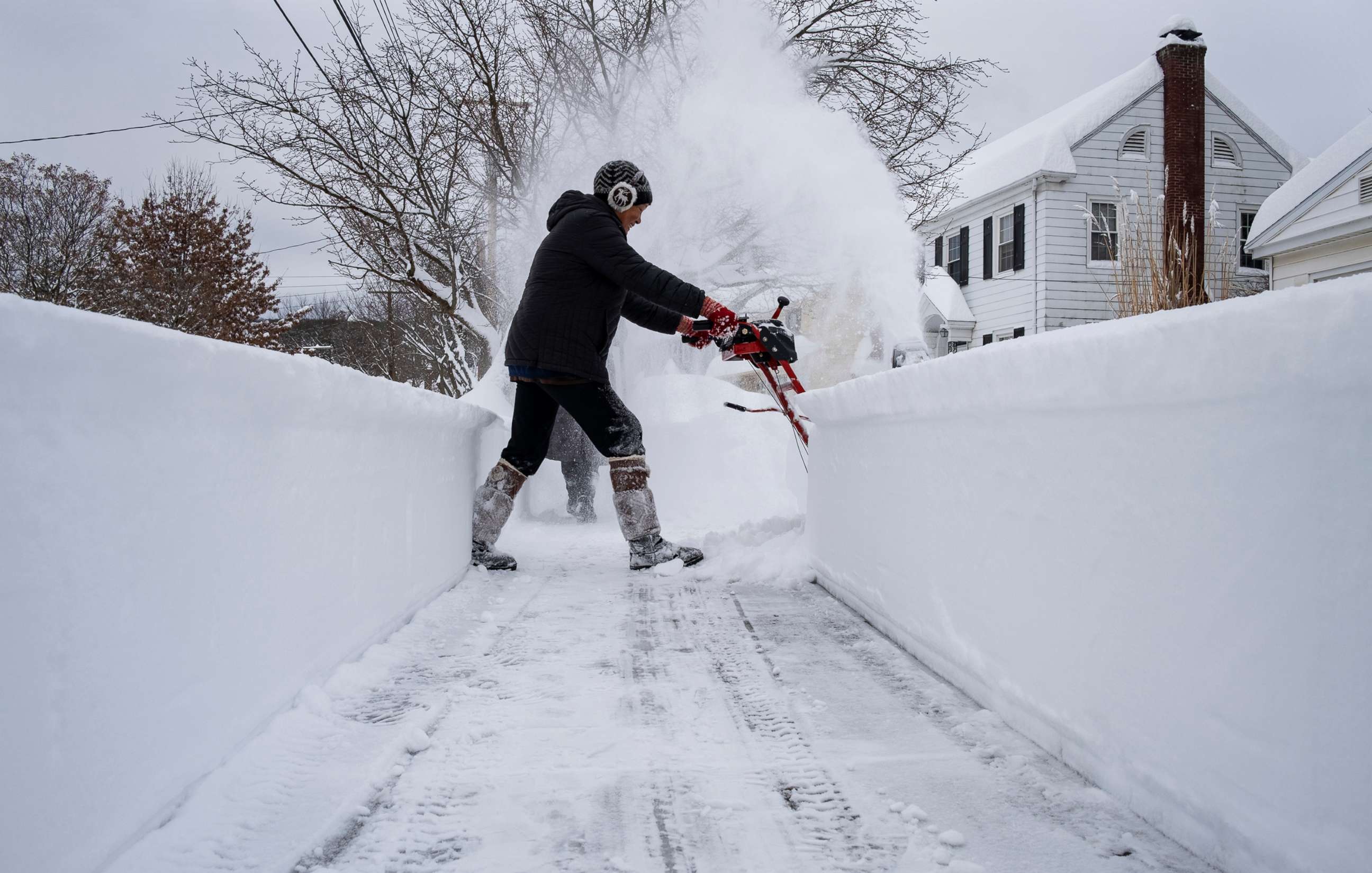 PHOTO: Linda Marzell clears a sidewalk using a snowblower after a heavy snowfall in Binghamton, N.Y., Dec. 17, 2020.