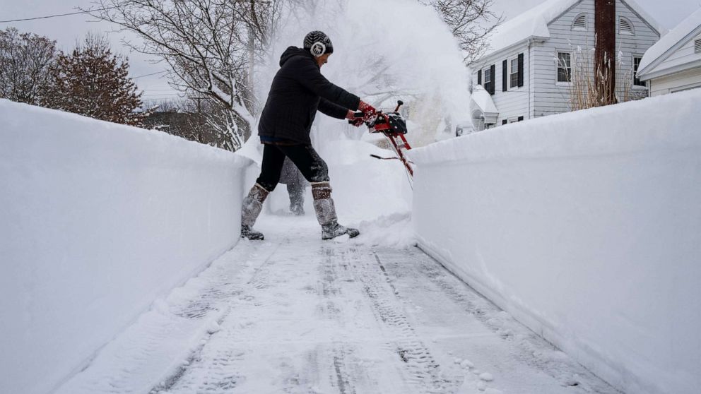 PHOTO: Linda Marzell clears a sidewalk using a snowblower after a heavy snowfall in Binghamton, N.Y., Dec. 17, 2020.