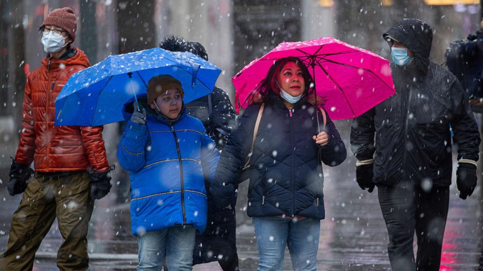 PHOTO: People walk as snow falls in New York City on February 7, 2021. 