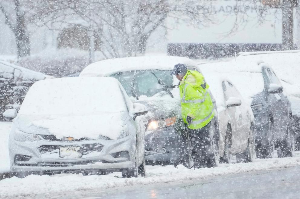 PHOTO: A person cleans off a car during a winter snow storm in Philadelphia, Feb. 13, 2024.