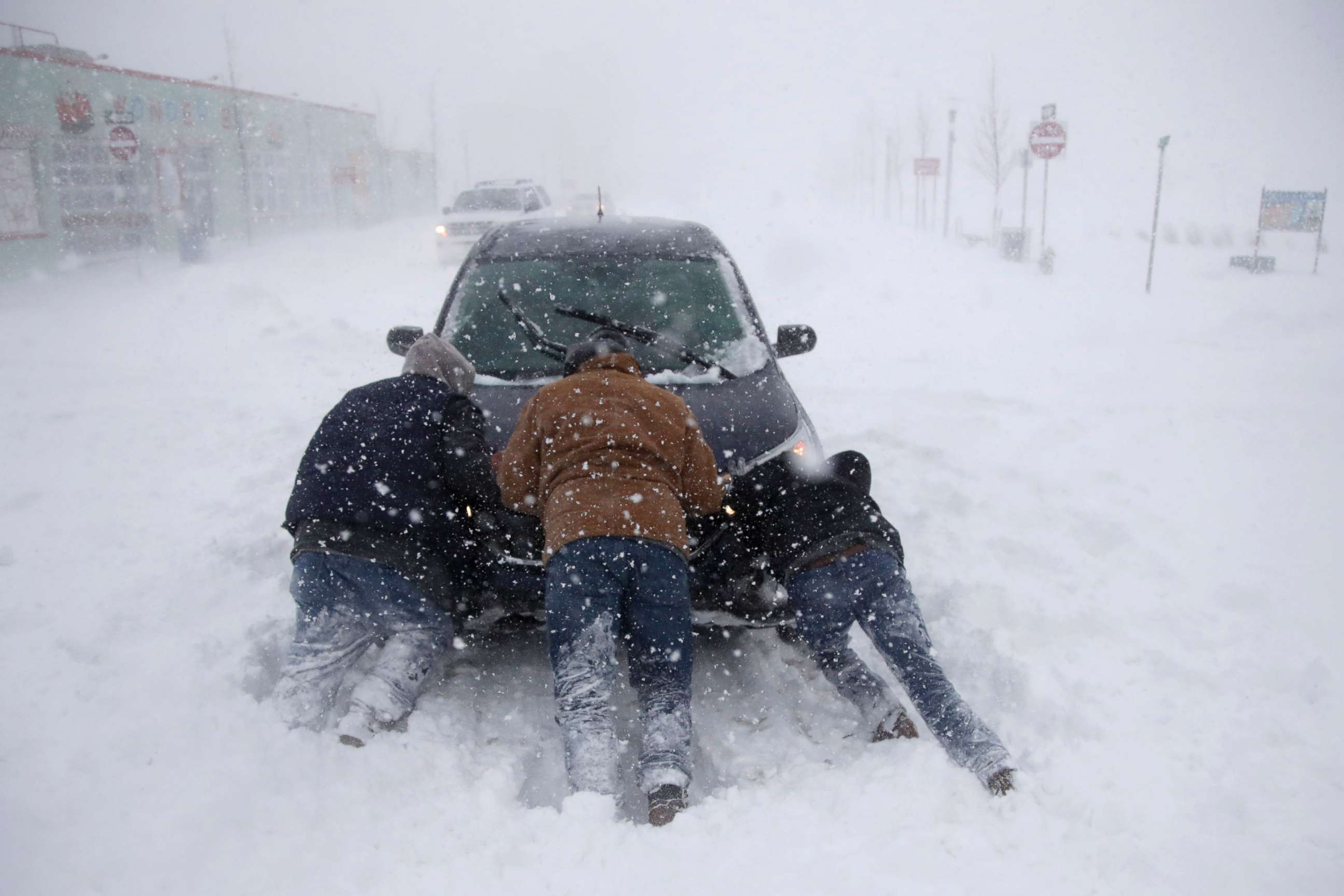 PHOTO: A group of men help a motorist after his vehicle was stuck in the snow near Asbury Park boardwalk during a snowstorm, Jan. 4, 2018, in Asbury Park, N.J. 