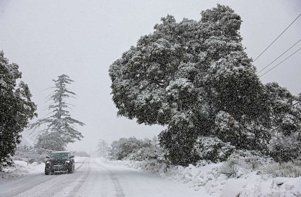 PHOTO: A vehicle drives through a snow storm in the San Gabriel Mountains in San Bernardino County near Los Angeles County, Feb. 24, 2023 in Mount Baldy, Calif.