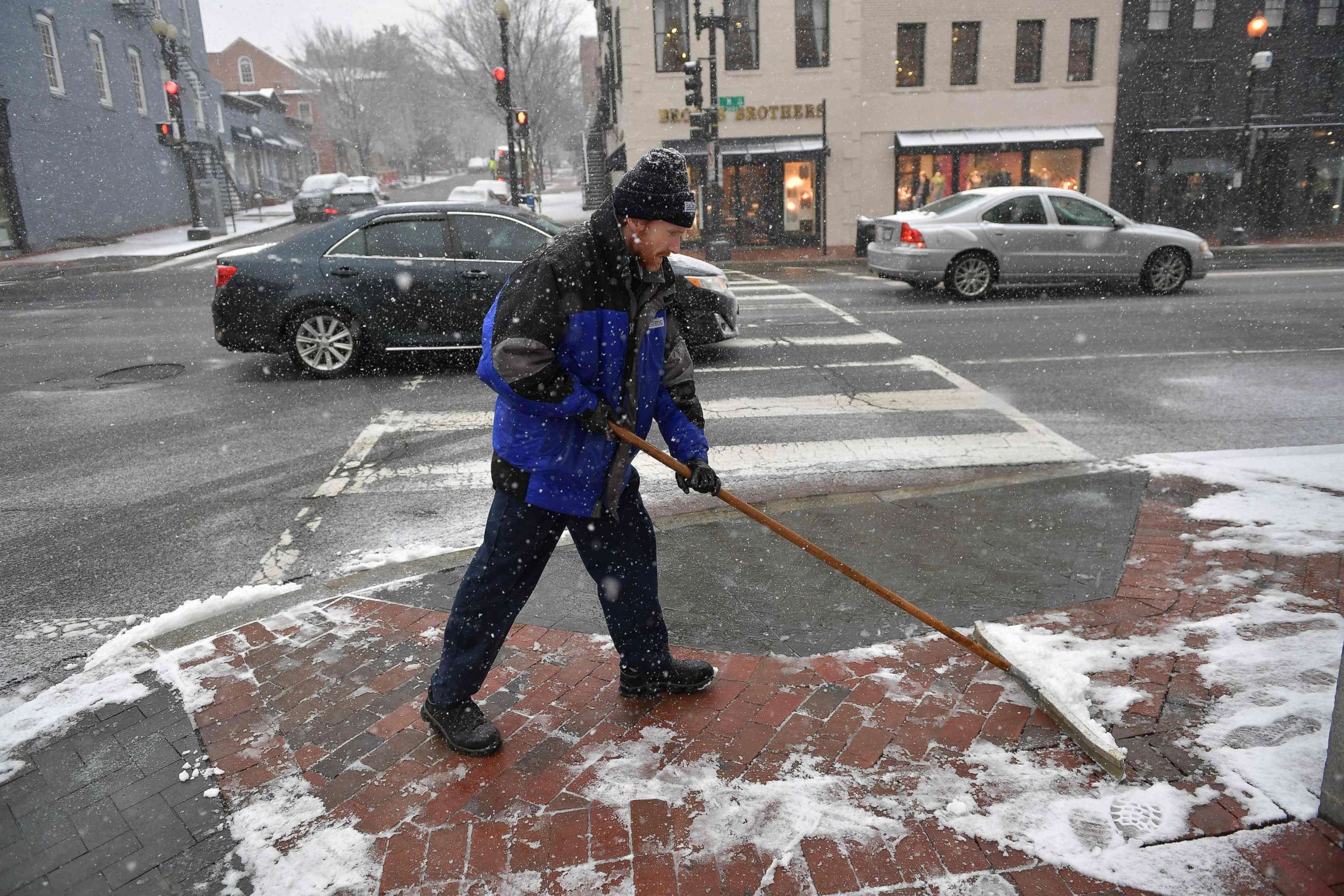 PHOTO: A worker shovels a sidewalk during the latest storm to hit the U.S. east coast, March 21, 2018, in Washington, DC.