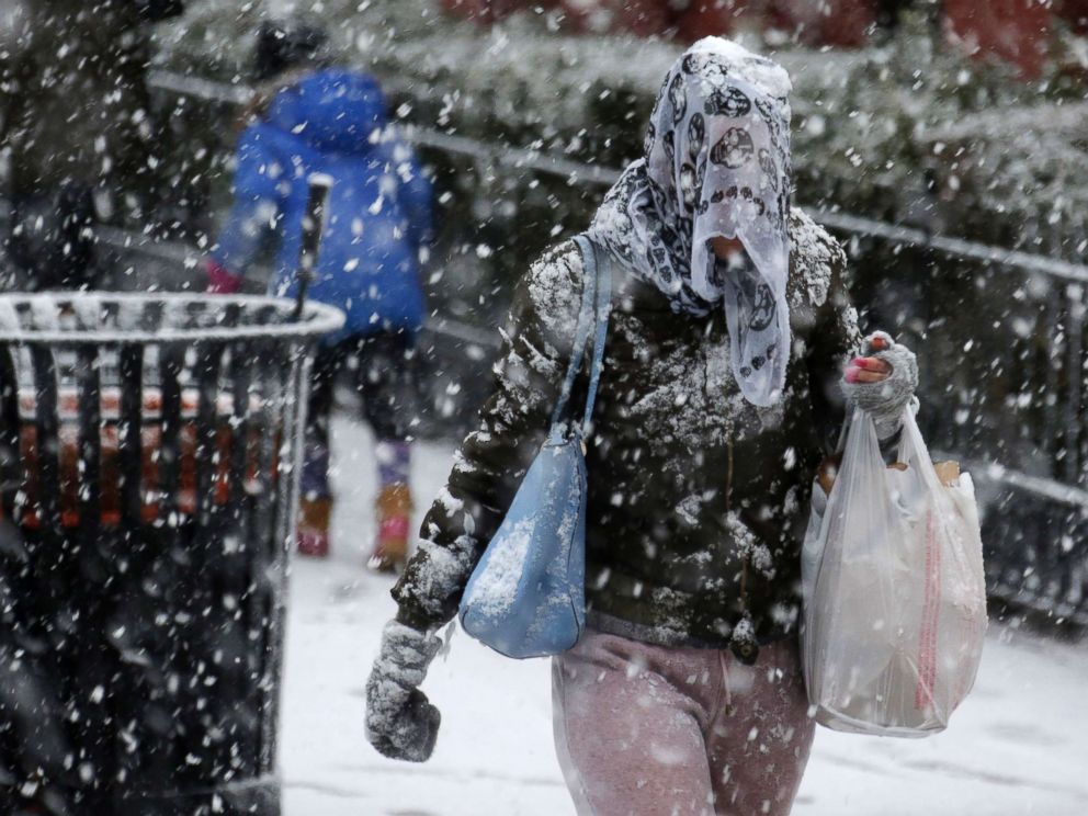 PHOTO: A woman puts a scarf over her head to try and keep the snow off in Hoboken, N.J., March 7, 2018. 