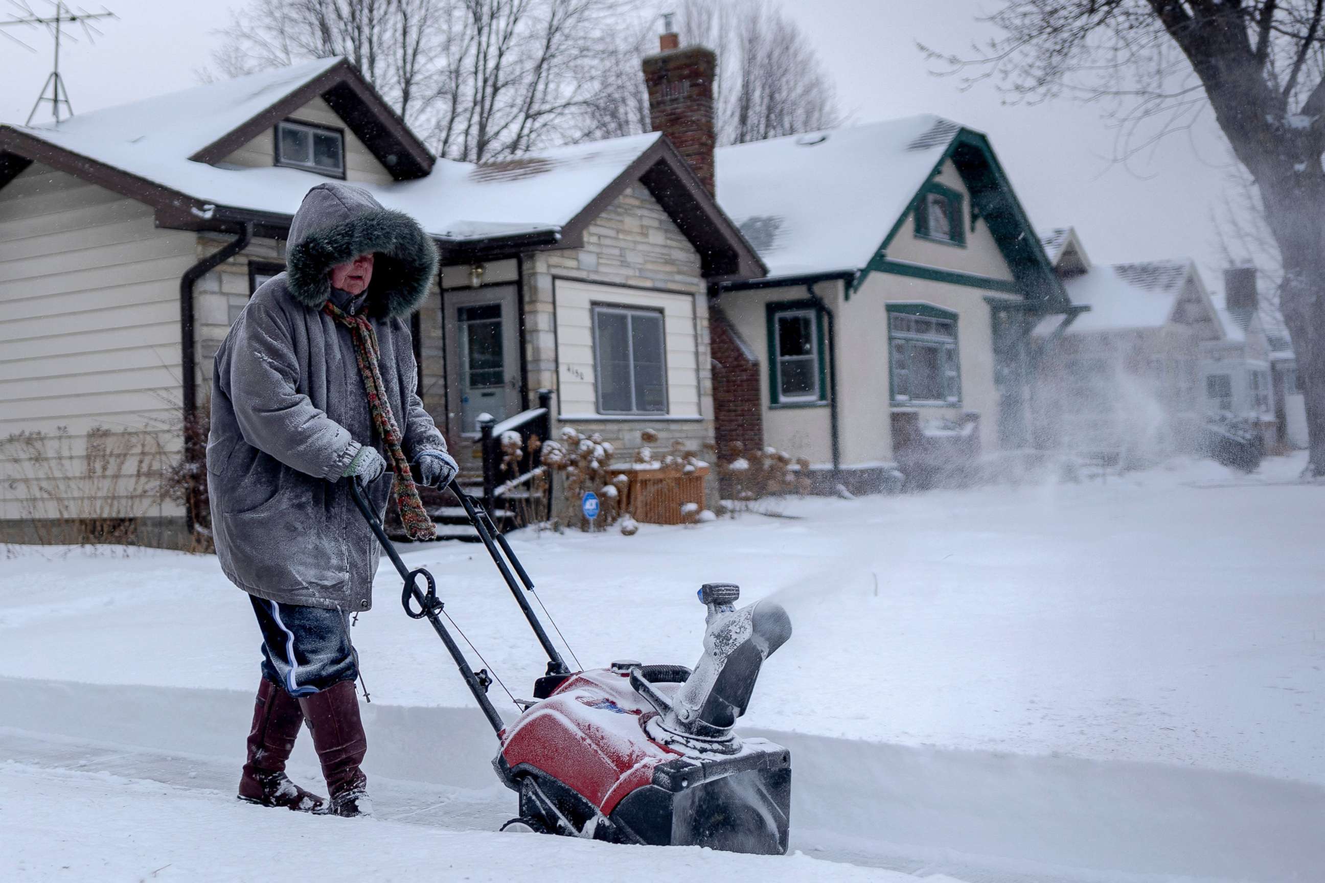 PHOTO: A woman uses a snowblower to clear the sidewalk during a heavy snowstorm in St. Paul, Minn., Feb. 22, 2022.