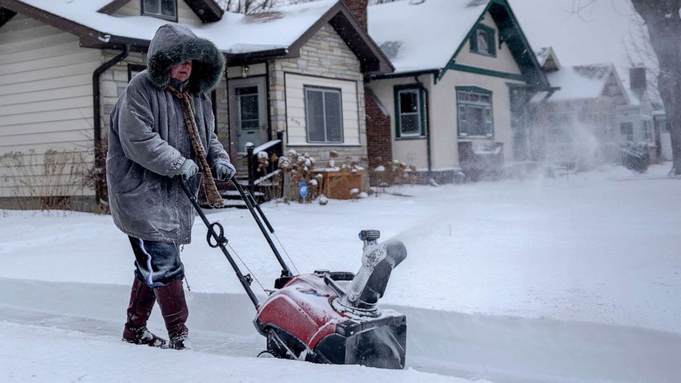 PHOTO: A woman uses a snowblower to clear the sidewalk during a heavy snowstorm in St. Paul, Minn., Feb. 22, 2022.