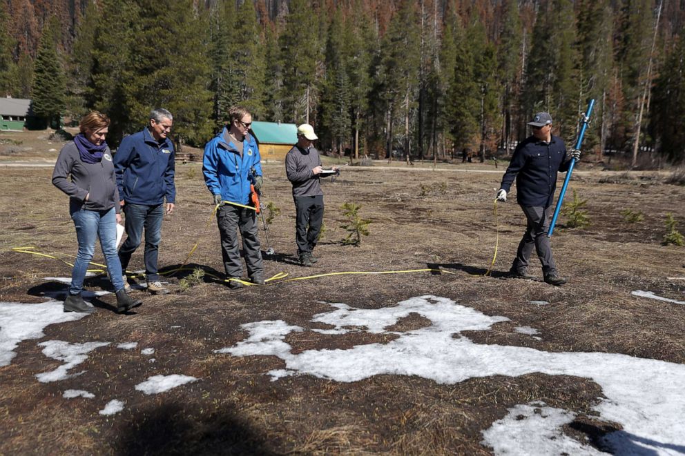 PHOTO: California Department of Water Resources (DWR) Director Karla Neme walks on dry ground with Wade Crowfoot, Anthony Burdock and Sean de Guzman, as they conduct a monthly snowpack survey on April 1, 2022, near Twin Bridges, Calif.