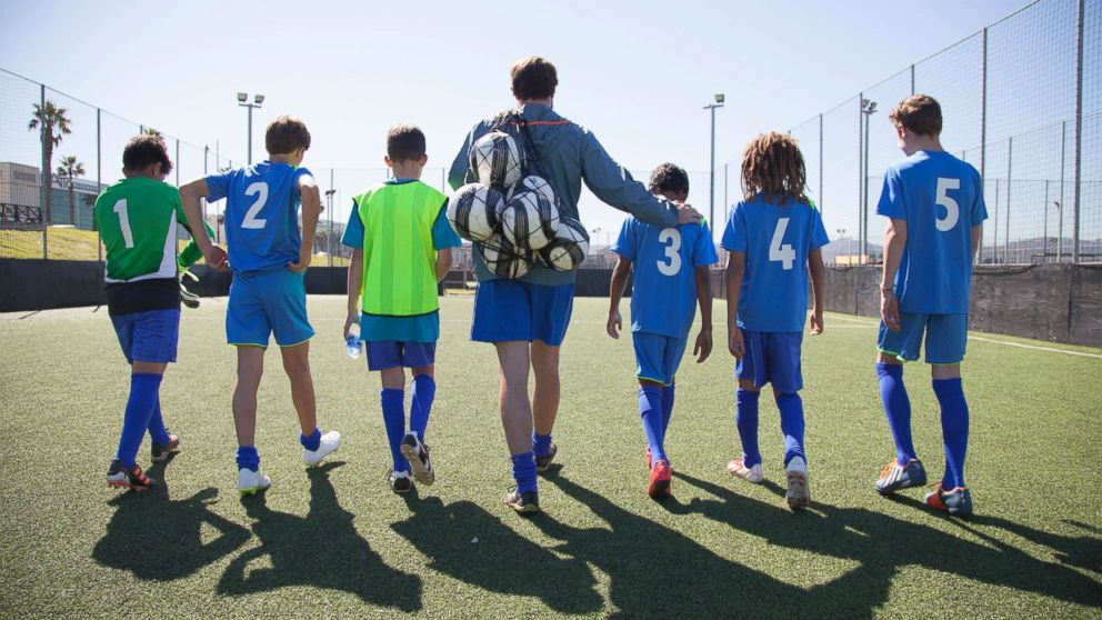 PHOTO: Boys in a soccer team walk out for a game with their coach in this undated stock photo.
