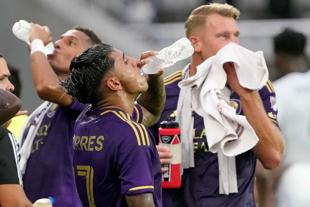 PHOTO: Orlando City's Rafael Santos, Facundo Torres and Robin Jansson, from left, cool off from the heat as play was stopped during the first half of the team's MLS soccer match, July 4, 2023, in Orlando, Fla.