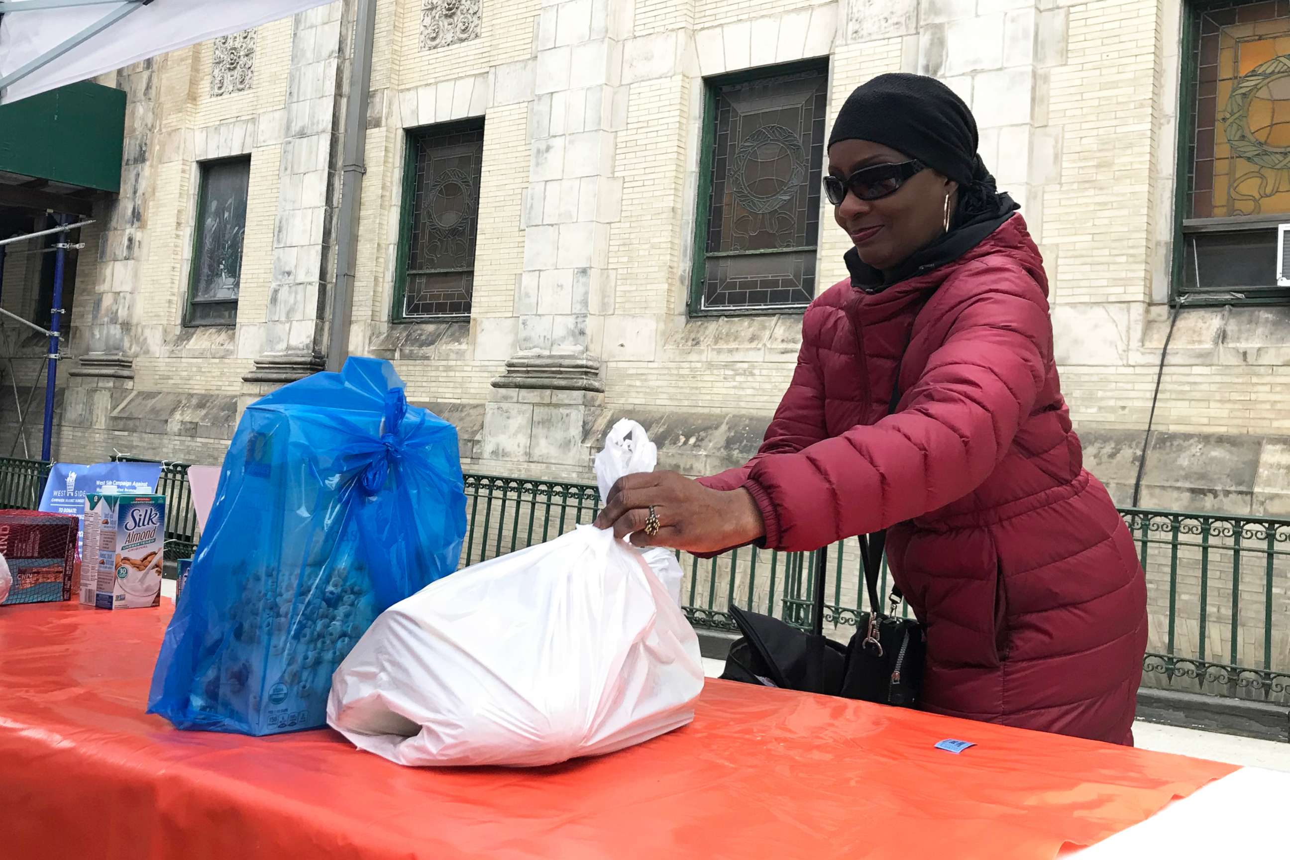 PHOTO: Patricia Sylvester, 67, picks up groceries at the West Side Campaign Against Hunger food pantry outside St. Paul and St. Andrew United Methodist Church in New York, March 25, 2020.
