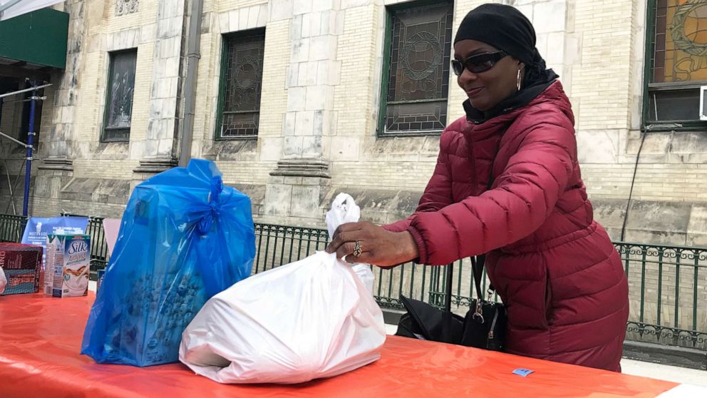 PHOTO: Patricia Sylvester, 67, picks up groceries at the West Side Campaign Against Hunger food pantry outside St. Paul and St. Andrew United Methodist Church in New York, March 25, 2020.