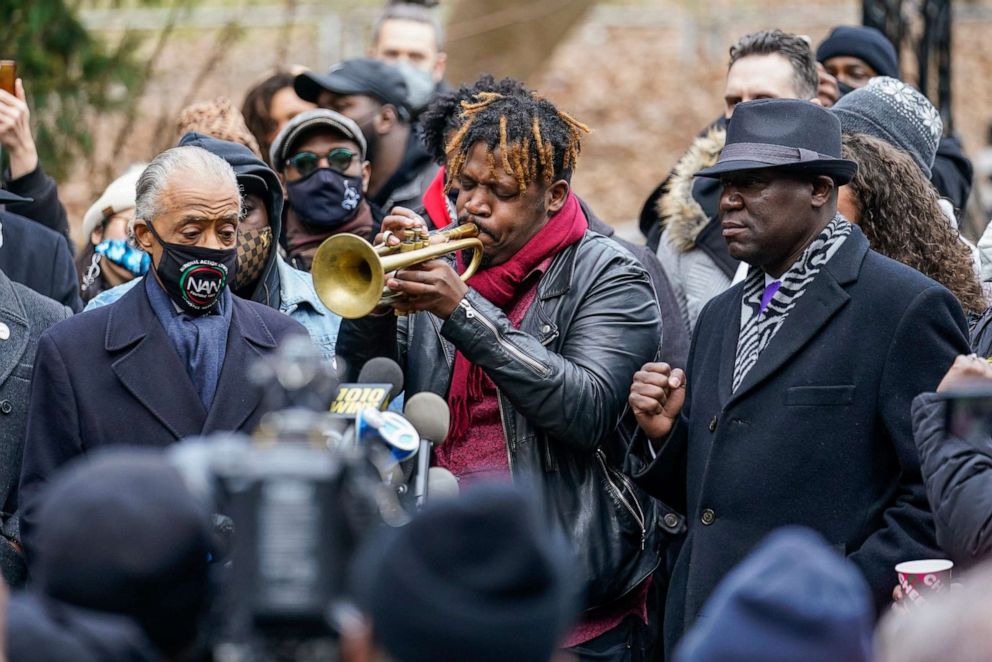 PHOTO: Keyon Harrold Sr. plays the trumpet as attorney Ben Crump, right, and Rev. Al Sharpton, left, listen during a news conference Wednesday, Dec. 30, 2020, in New York. 